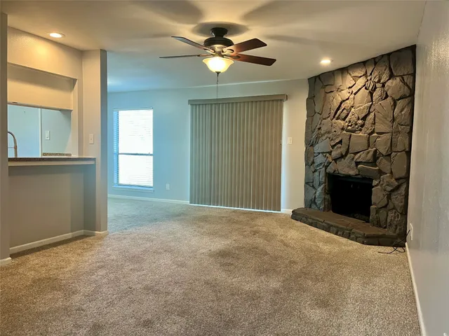en empty room with windows and ceiling fan