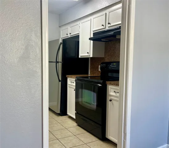 a kitchen with a refrigerator and cabinets