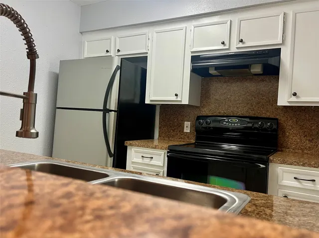 a kitchen with granite countertop a refrigerator and a stove