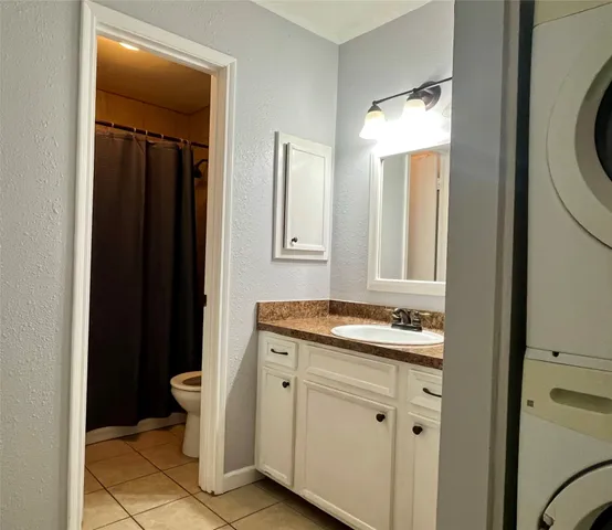 a bathroom with a granite countertop sink toilet and mirror