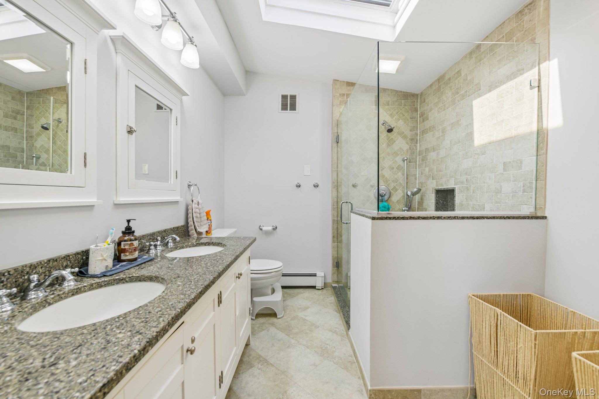 2821 Colonial Avenue Merrick, NY 11566 - Photo 19 of 29 a bathroom with a granite countertop sink mirror and a bathtub