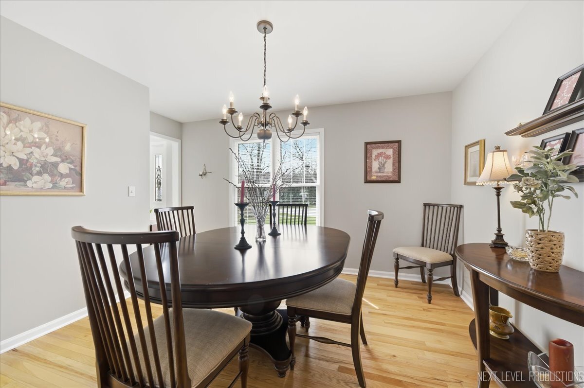 2984 Marshfield Court Elgin, IL 60124 - Photo 15 of 40 a view of a dining room with furniture wooden floor and chandelier