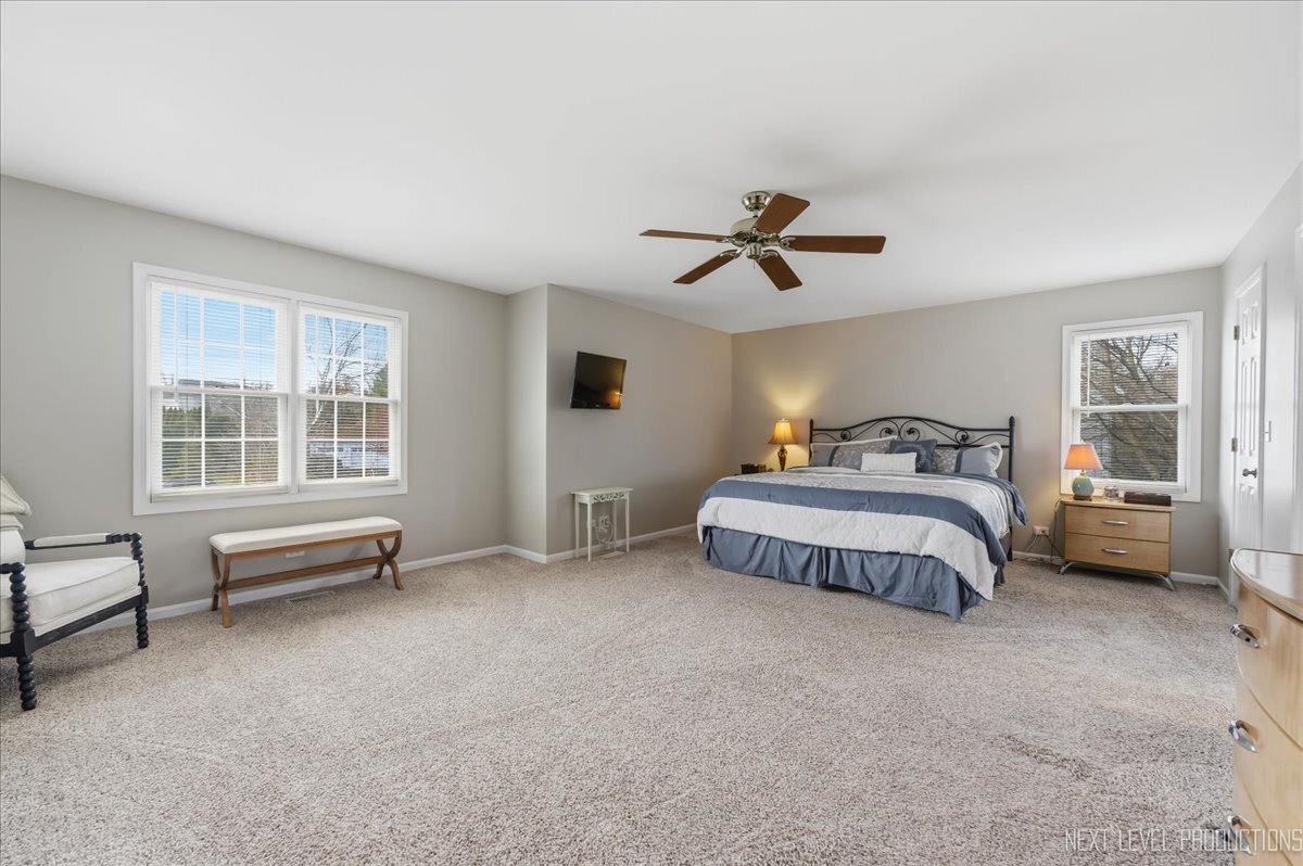 2984 Marshfield Court Elgin, IL 60124 - Photo 21 of 40 a bedroom with a bed and a chandelier