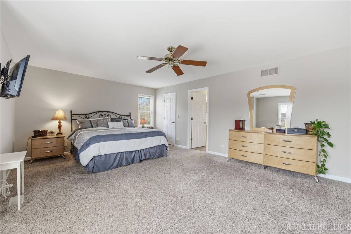2984 Marshfield Court Elgin, IL 60124 - Photo 22 of 40 a bedroom with a bed and a chandelier