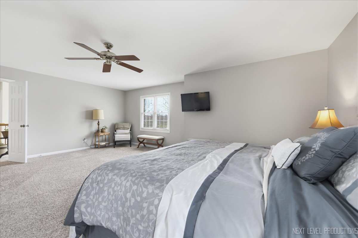 2984 Marshfield Court Elgin, IL 60124 - Photo 23 of 40 a spacious bedroom with a bed a window and a couch