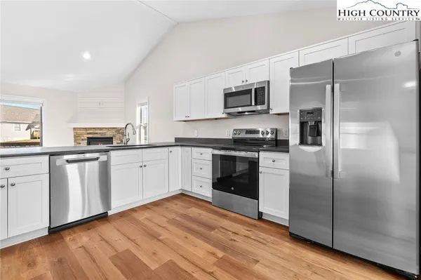 a kitchen with stainless steel appliances a refrigerator sink and white cabinets