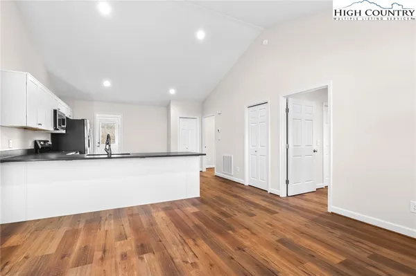a view of kitchen with stainless steel appliances granite countertop a stove top oven a sink and a microwave
