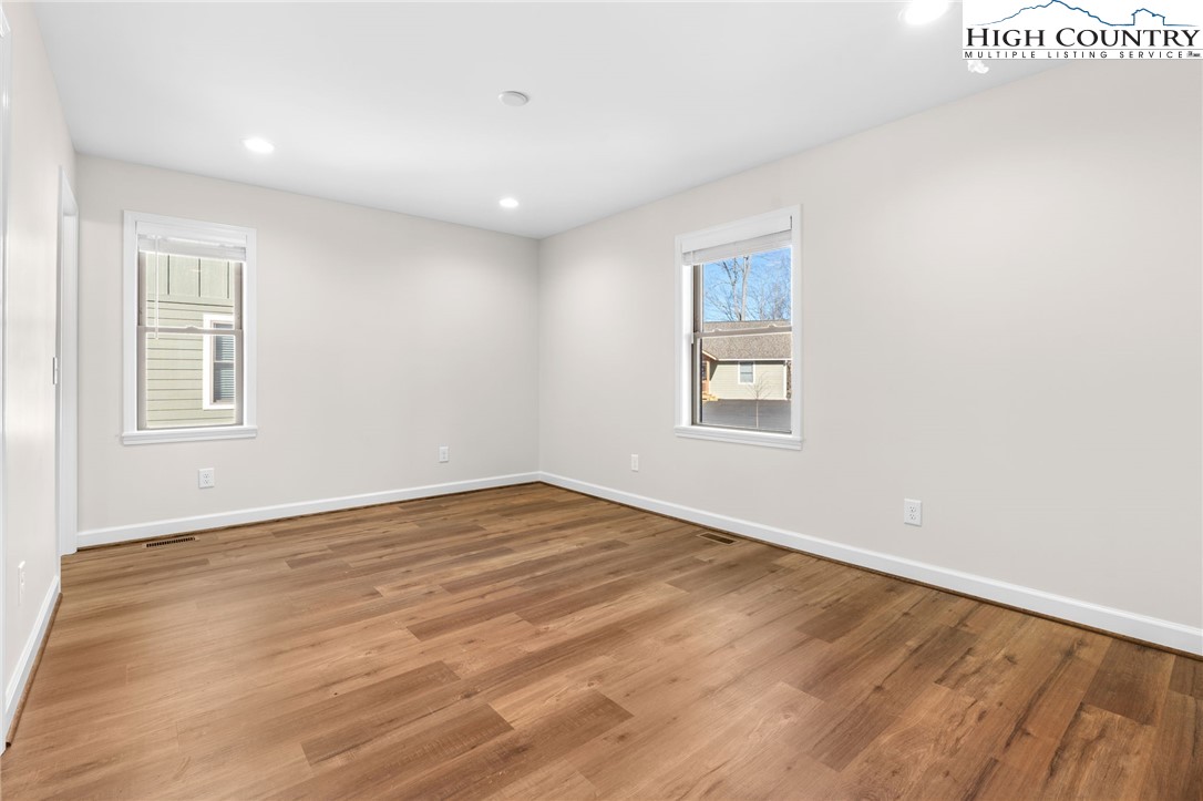 245 Ava Way, Unit 108 Boone, NC 28607 - Photo 15 of 29 a view of an empty room with wooden floor and a window