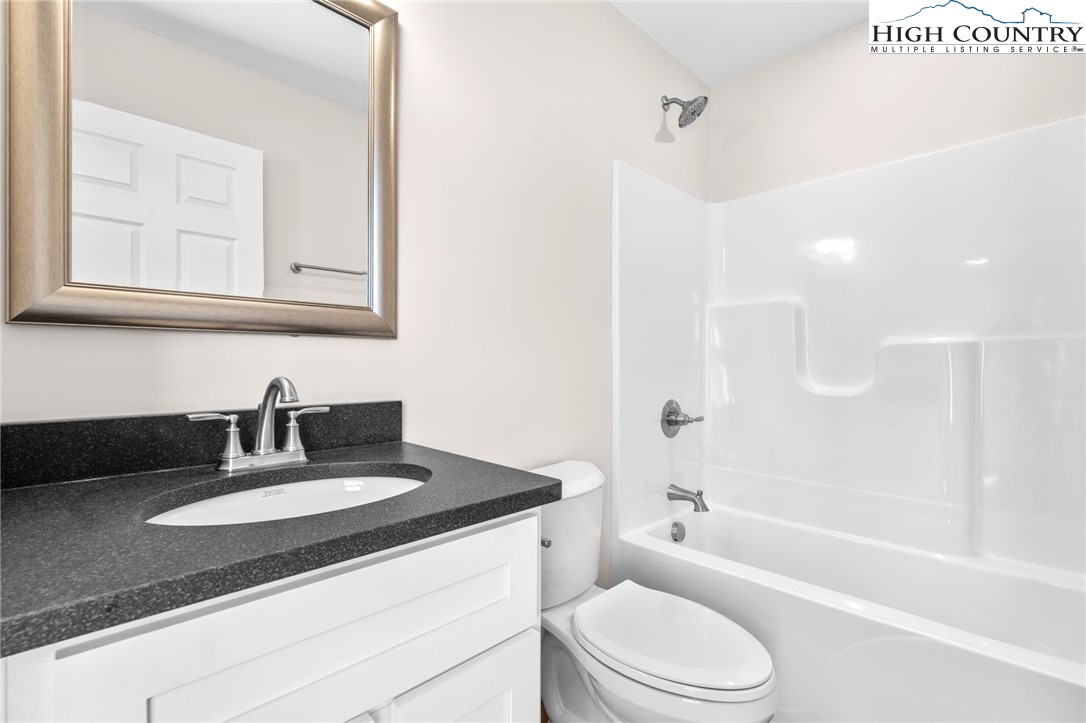 245 Ava Way, Unit 108 Boone, NC 28607 - Photo 17 of 29 a bathroom with a granite countertop sink toilet and shower