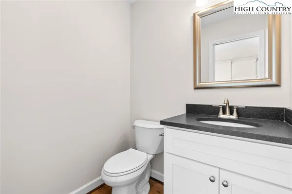 a bathroom with a toilet sink vanity and mirror