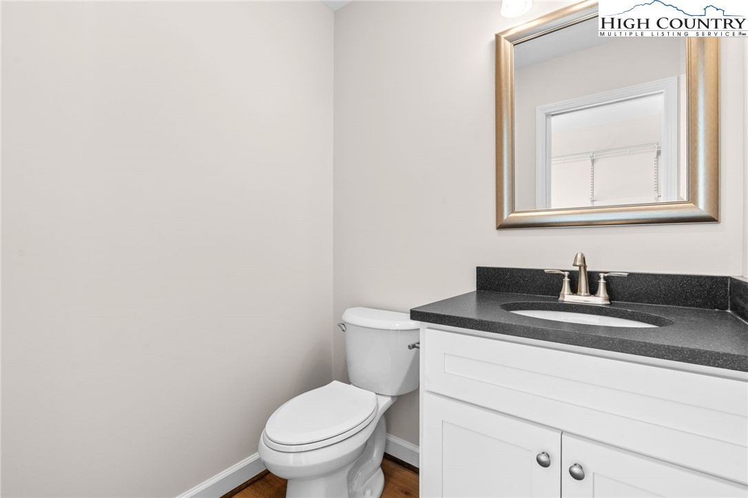 245 Ava Way, Unit 108 Boone, NC 28607 - Photo 24 of 29 a bathroom with a toilet sink vanity and mirror