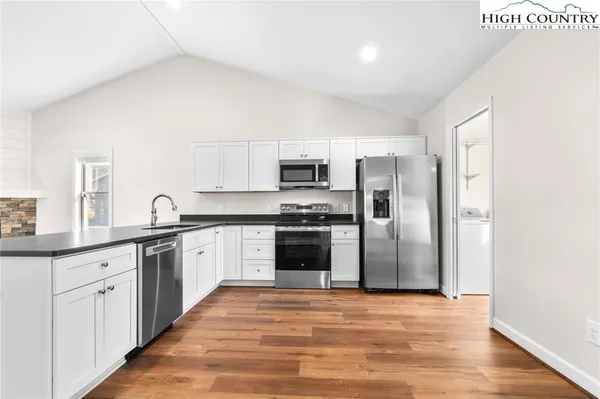 a kitchen with granite countertop a refrigerator and a stove top oven