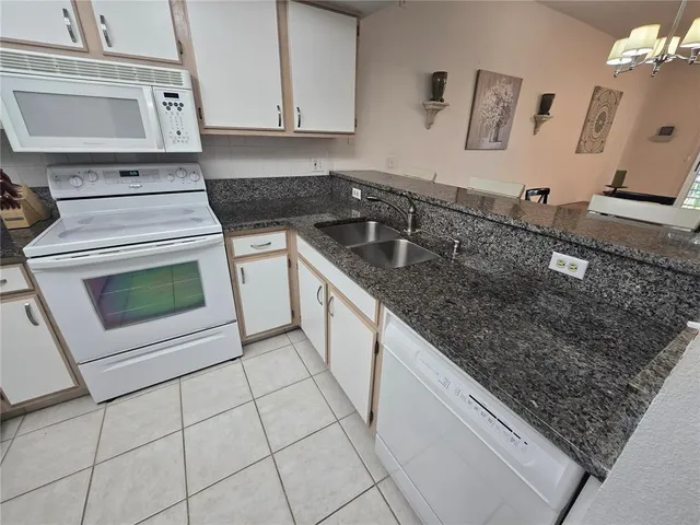 a kitchen with stainless steel appliances granite countertop a sink stove top oven and cabinets