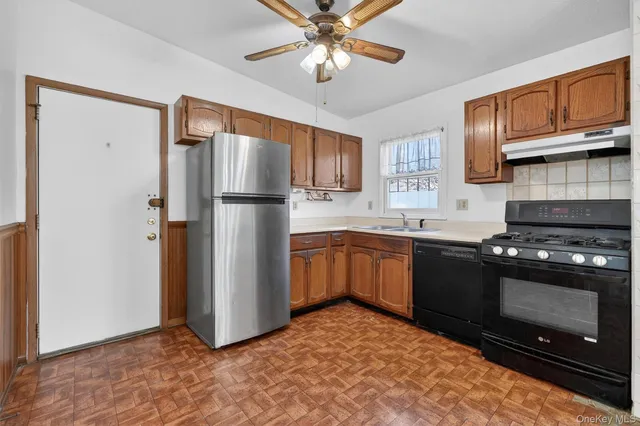 a kitchen with stainless steel appliances granite countertop a stove a refrigerator and a sink with cabinets