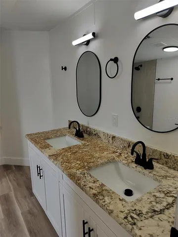 a bathroom with a granite countertop sink and a mirror