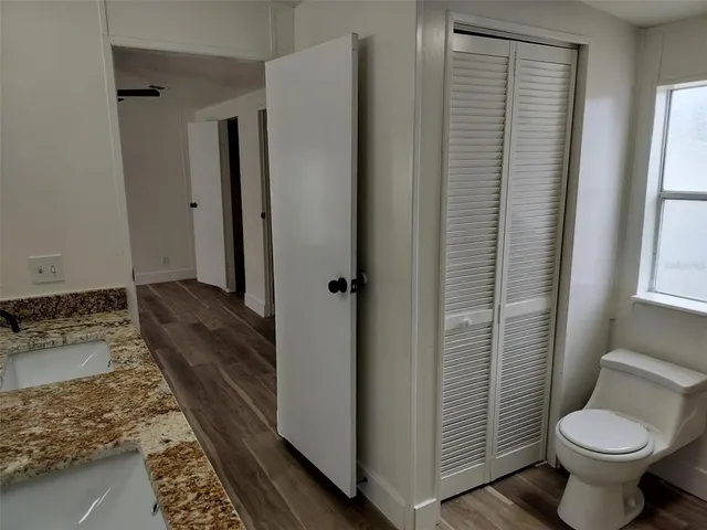 a bathroom with a granite countertop toilet and a sink