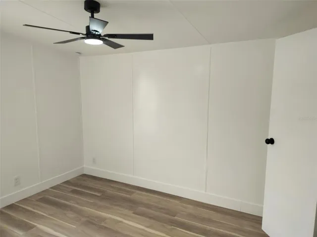 a view of a room with wooden floor and fan