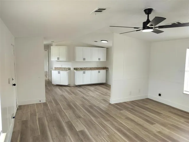a view of a kitchen with wooden floor and a sink