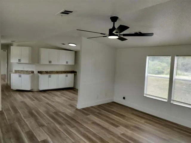a view of a kitchen with a sink and dishwasher cabinet with wooden floor