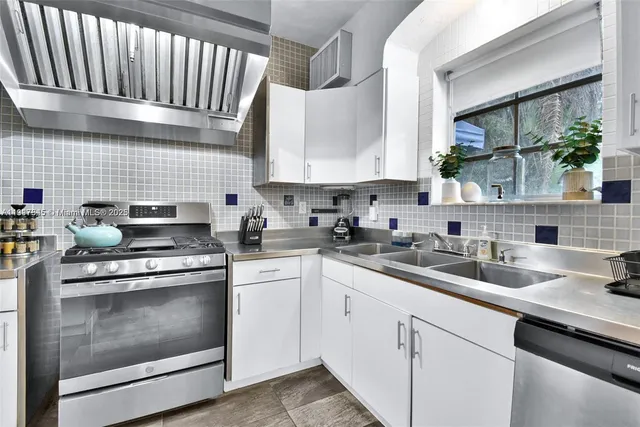 a kitchen with stainless steel appliances granite countertop a stove sink and cabinets