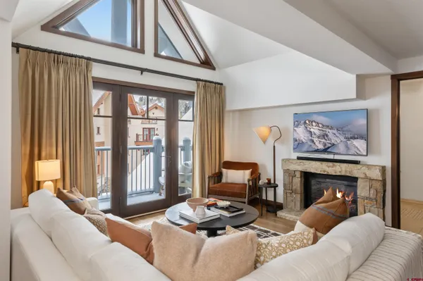 a living room with furniture a fireplace and a large window