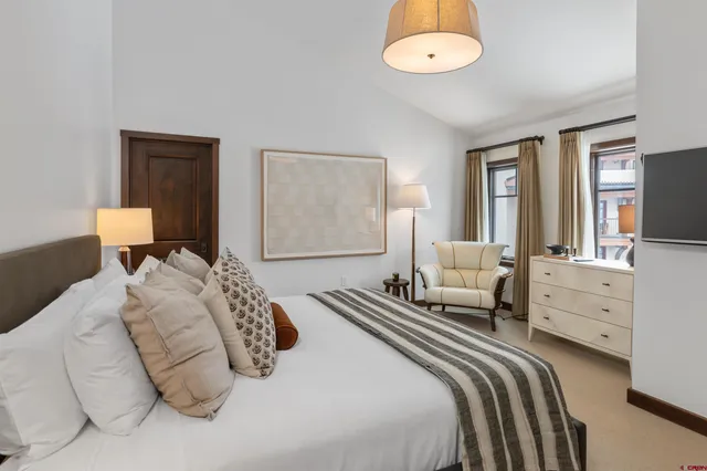 a bedroom with a bed and a chandelier