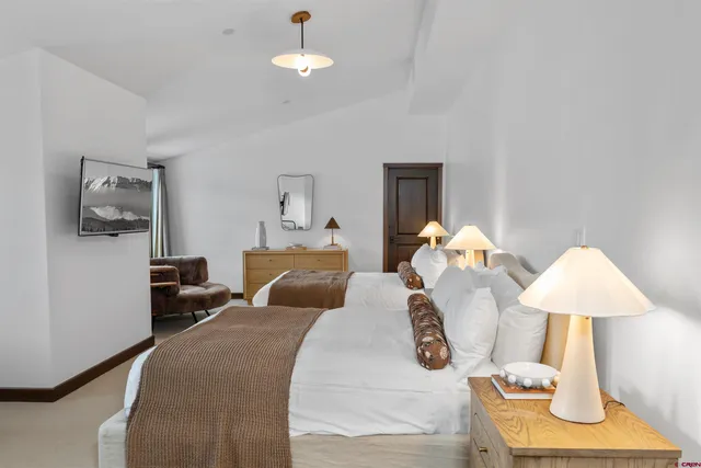 a bedroom with furniture and a flat screen tv