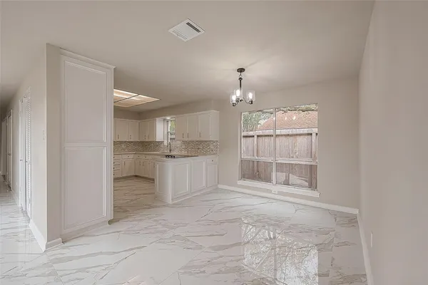 a large white kitchen with granite countertop lots of counter top space