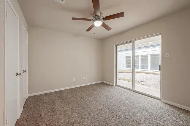 a view of an empty room and a ceiling fan