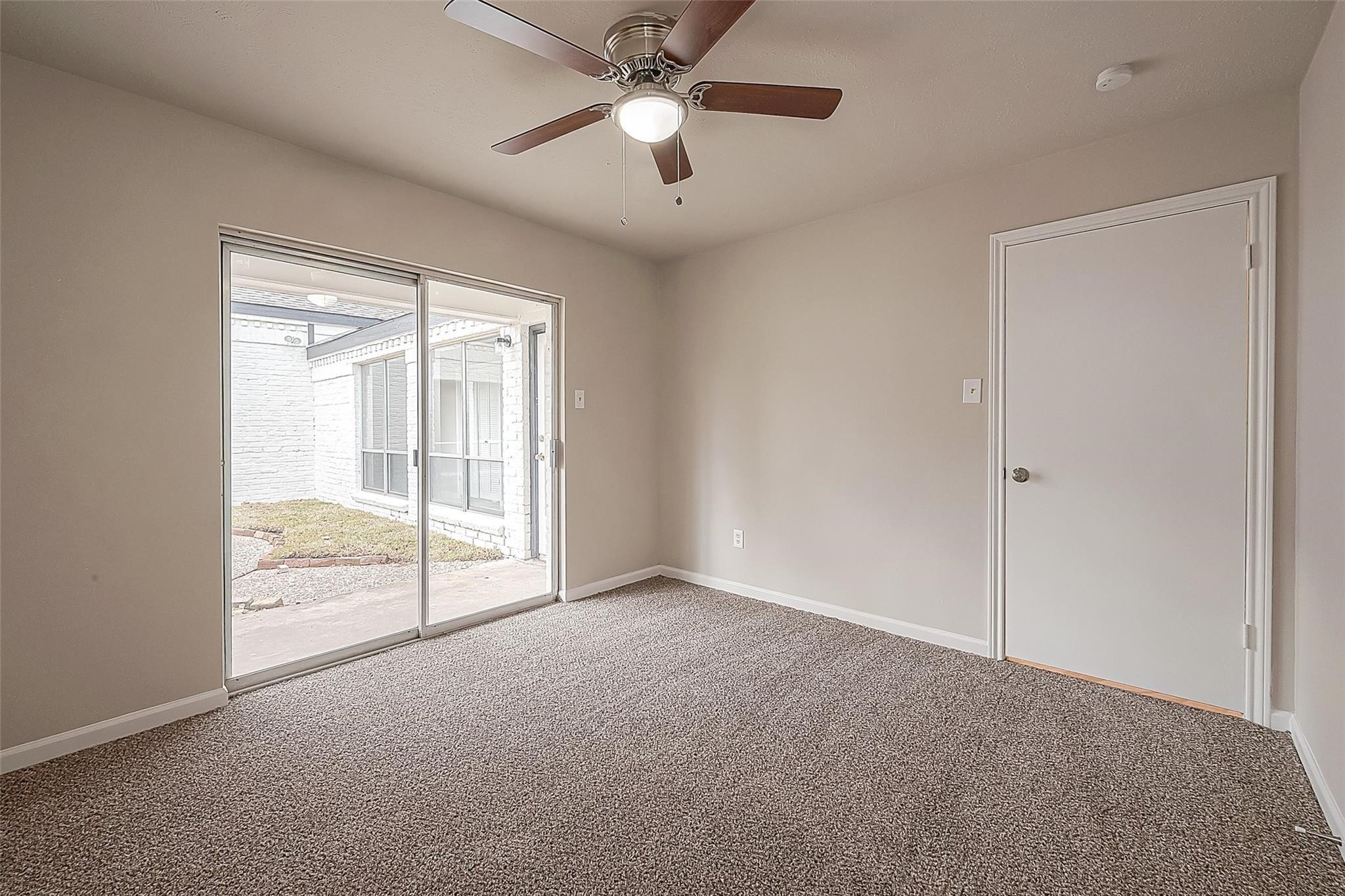 10811 Villa Lea Lane Houston, TX 77071 - Photo 20 of 34 an empty room with chandelier fan and windows