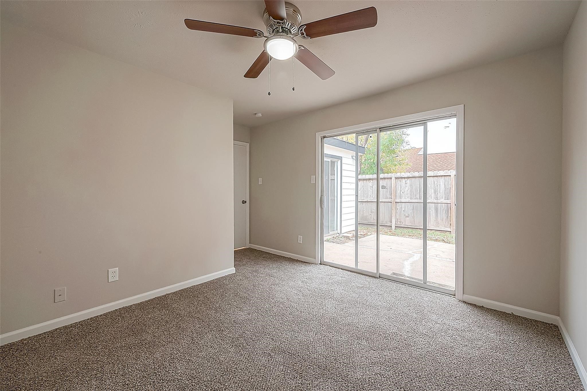 10811 Villa Lea Lane Houston, TX 77071 - Photo 23 of 34 an empty room with chandelier fan and windows