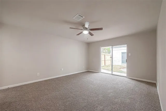 a view of an empty room with a ceiling fan