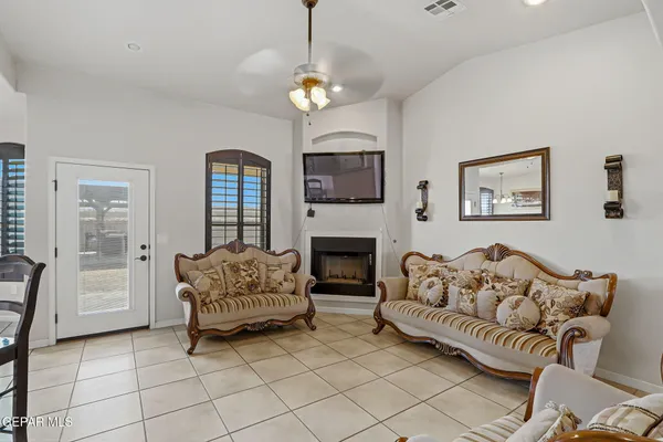 a living room with furniture a fireplace and a chandelier
