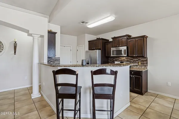 a kitchen with stainless steel appliances granite countertop a stove a microwave a sink and a refrigerator