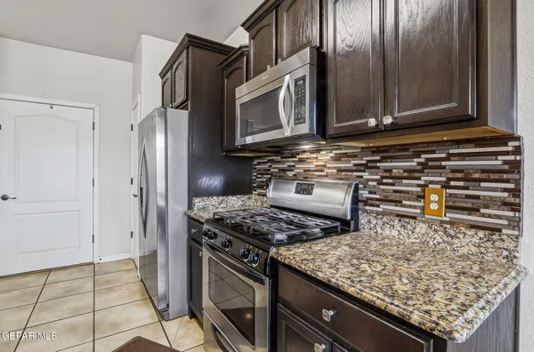 a kitchen with stainless steel appliances granite countertop a stove and a microwave