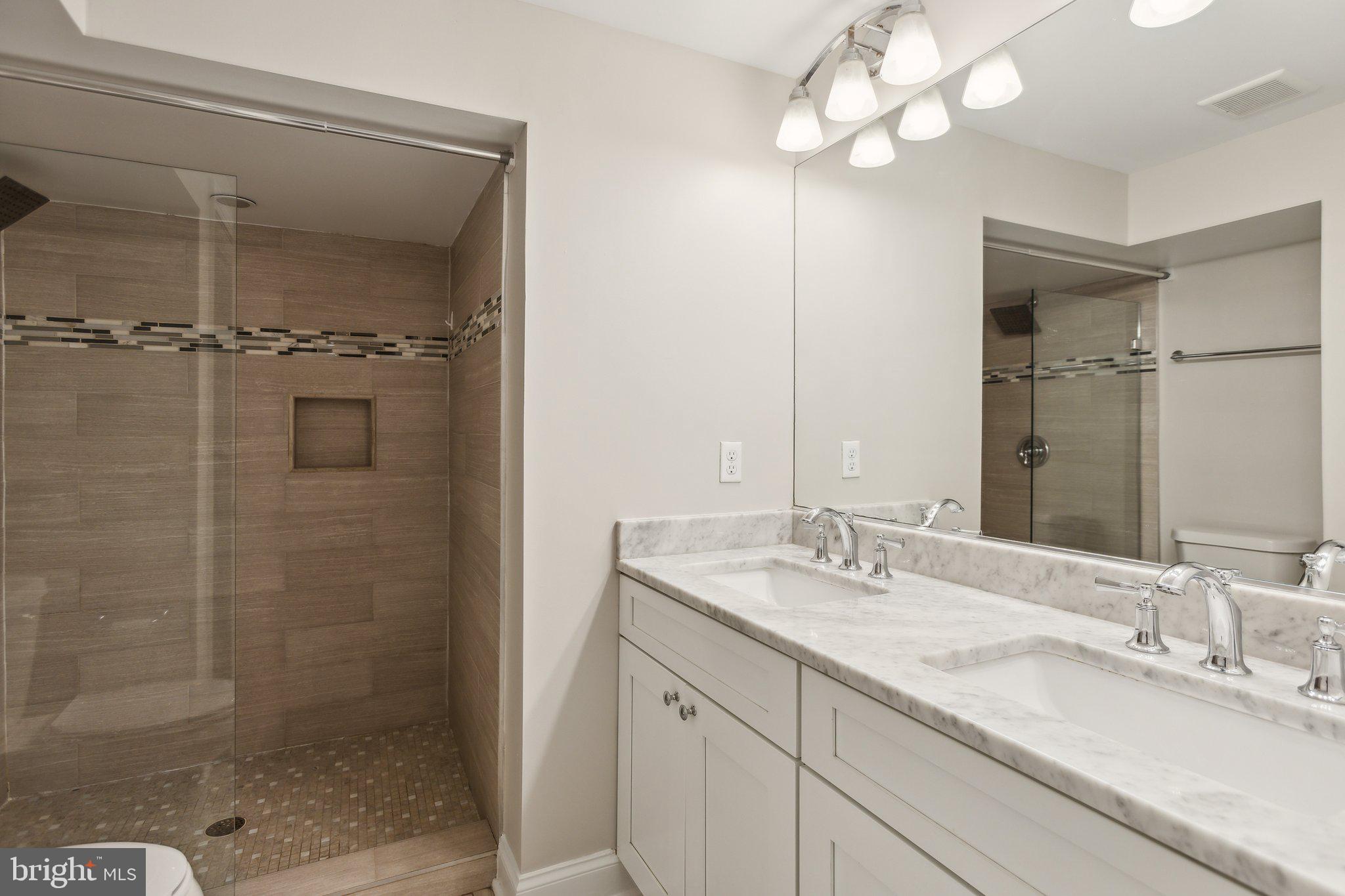 39 U Street Northeast, Unit 1 Washington, DC 20002 - Photo 14 of 22 a bathroom with a granite countertop sink a mirror and shower