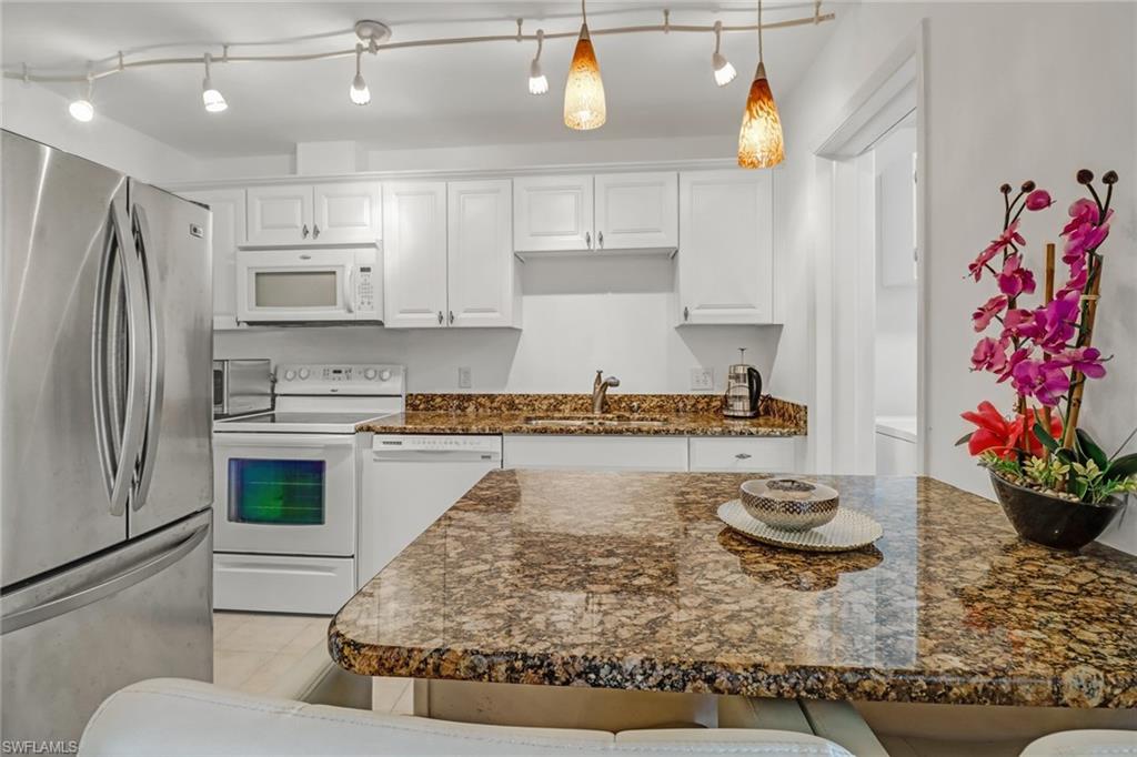 788 Park Shore Drive, Unit E32 Naples, FL 34103 - Photo 11 of 35 a kitchen with kitchen island stainless steel appliances a sink stove and refrigerator