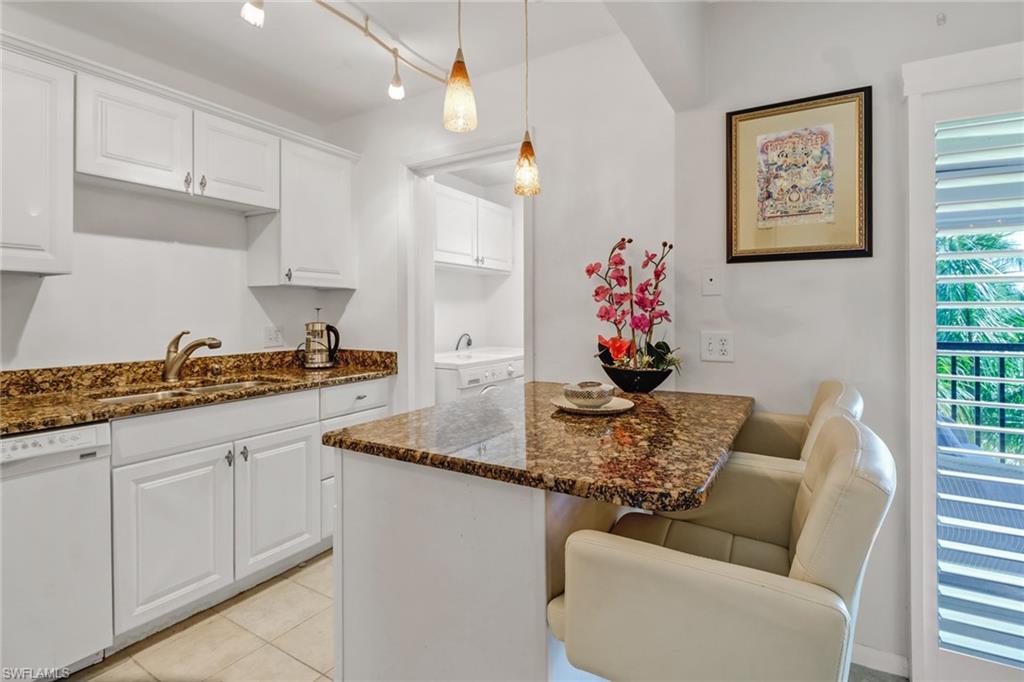 788 Park Shore Drive, Unit E32 Naples, FL 34103 - Photo 12 of 35 a kitchen with stainless steel appliances granite countertop a couch a white cabinets and couches