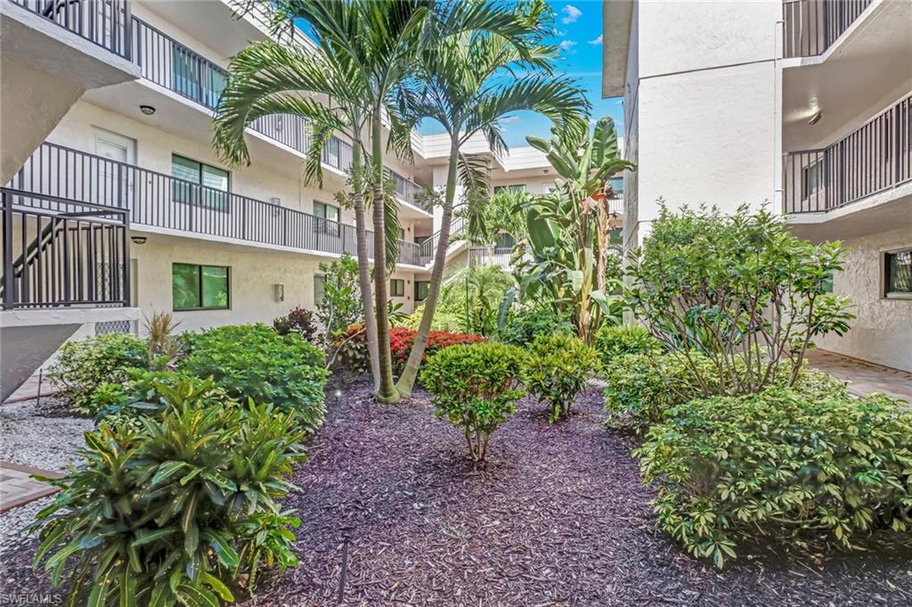 788 Park Shore Drive, Unit E32 Naples, FL 34103 - Photo 4 of 35 a view of a garden with a building