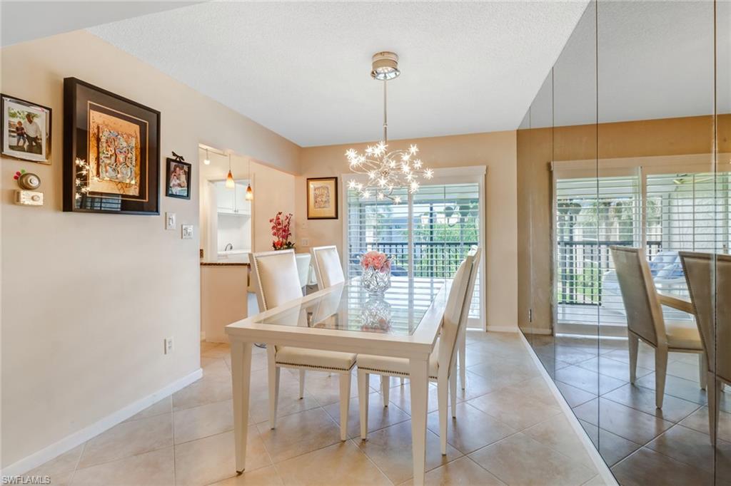 788 Park Shore Drive, Unit E32 Naples, FL 34103 - Photo 9 of 35 a dining room with furniture a chandelier and wooden floor