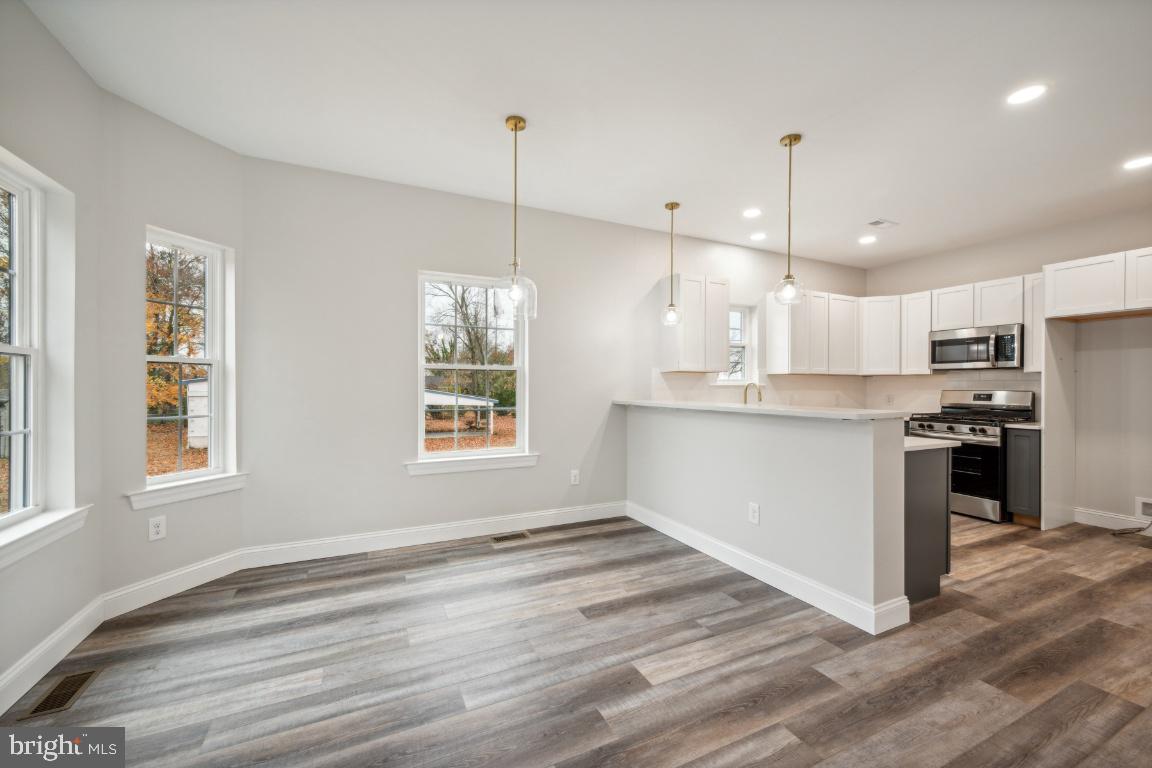 459 Berkley Road Mantua, NJ 08051 - Photo 5 of 28 a view of kitchen with granite countertop stainless steel appliances cabinets a sink and a wooden floor