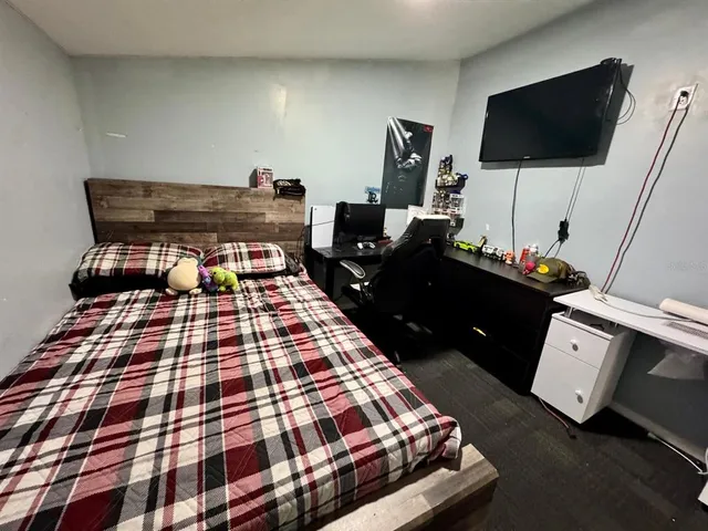 a bedroom with a bed and flat screen tv