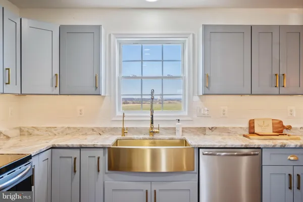 a kitchen with granite countertop a sink and cabinets