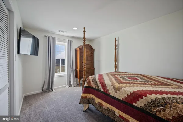 a bedroom with a bed and a large mirror