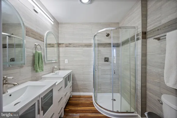 a bathroom with a double vanity sink toilet and shower