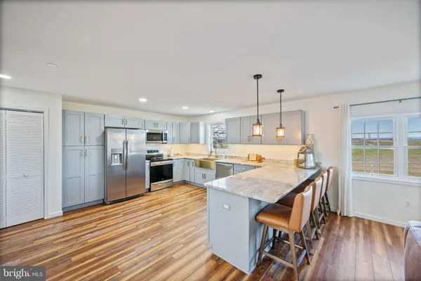a open kitchen with stainless steel appliances granite countertop a stove and a refrigerator