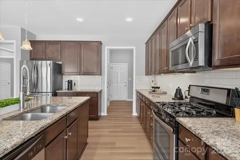 a kitchen with stainless steel appliances granite countertop a sink stove and refrigerator