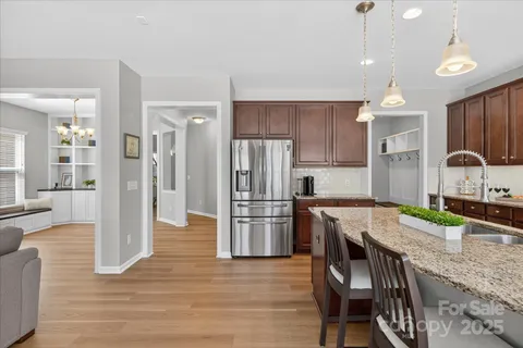 a kitchen with refrigerator a sink and chairs