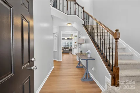 a view of staircase with lots of frames on wall and wooden floor