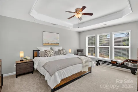 a bedroom with a bed flat screen tv and a large window